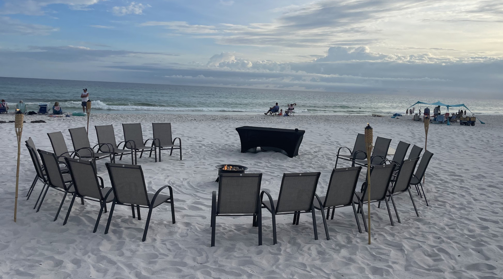 Large beach bonfire setup with chairs in circle